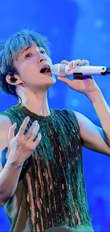 Singer passionately performing against a blue-lit stage background.