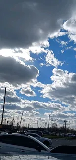 Vibrant blue sky with fluffy white clouds over cars.