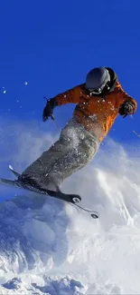 Snowboarder jumps dynamically against a blue sky.