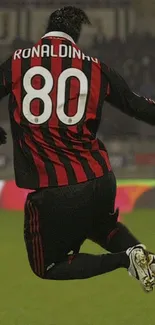 Soccer player in action with red and black jersey jumping mid-air.