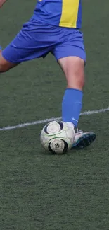 Soccer player kicking ball on green field.