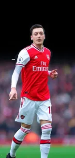 Soccer player in red jersey, stadium background.