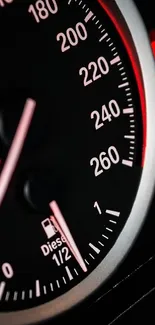 Close-up of a black and red speedometer in a car dashboard.