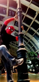 Spider-Man strikes a dynamic pose on a pole, set against an architectural background.