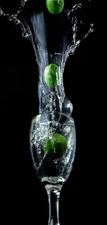 Dynamic lime splash in a glass on black background.