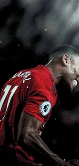 Football player celebrating in red jersey under spotlight.