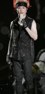 Dynamic stage performer in glittery black attire during a live concert.