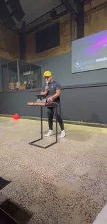 Man presenting on stage with a screen and balloons.