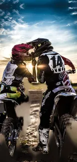 Motocross riders sharing a moment at sunset on a dirt track.