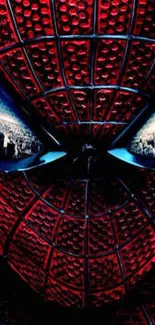 Close-up superhero mask with red and black web pattern and city reflections.