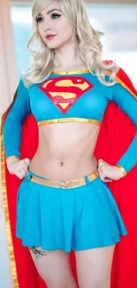 Cosplay superheroine in dynamic pose with colorful costume and red cape.