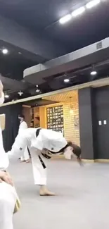 Athlete performing taekwondo kick in dojo.