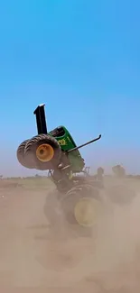 Tractor performing a stunt in a dusty field under a vibrant blue sky.