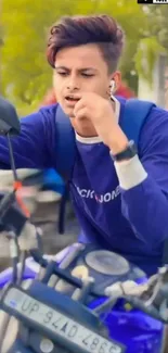 Young man riding a blue motorcycle in an urban setting.