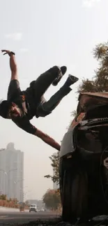 A daring stunt performer leaps over a rusty car in an urban cityscape setting.