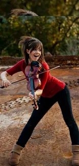 Young violinist playing energetically outdoors on a rustic backdrop.