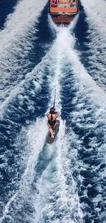 A wakeboarder pulled by a boat on open blue waters.