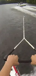 Hands gripping ski handle on a water skiing adventure behind a boat.