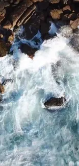 Aerial view of waves crashing over rocks on a serene coastline.