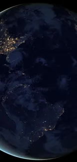 Dark globe of Earth with city lights visible from space at night.