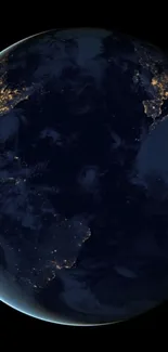 Night view of Earth from space with illuminated city lights.