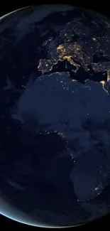 Earth at night with illuminated city lights viewed from space.