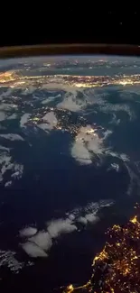 Earth from space at night with glowing city lights and blue ocean.