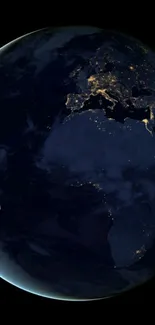 Earth at night with glowing city lights viewed from space.
