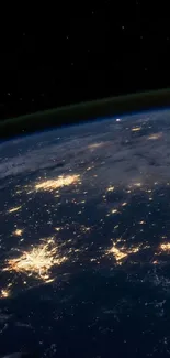 View of Earth from space at night with city lights glowing.