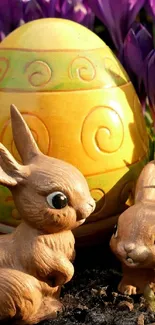 Toy bunnies with Easter egg and purple flowers in the background.