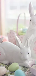 Ceramic bunnies with pastel eggs in soft pink light.