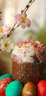 Easter cake with decorated eggs and pink blossoms on a festive plate.