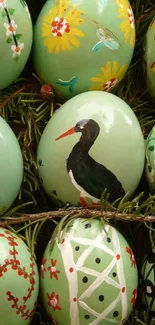 Hand-painted Easter eggs with floral designs and lush greenery in the background.