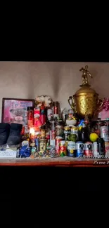Eclectic shelf with bottles, a trophy, and a photo frame displayed.