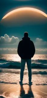 Silhouette stands on beach with eclipse over ocean, creating a serene view.