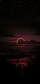 Dark red eclipse over alien landscape with starry sky.