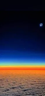 Solar eclipse over colorful horizon with clouds and vibrant sky hues.