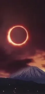 Solar eclipse casting glow over mountain at dusk.