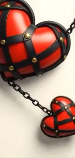 Two chained red hearts with black straps on a wallpaper.