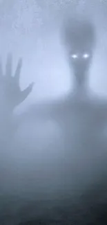 A shadowy alien figure with glowing eyes on a foggy gray background.