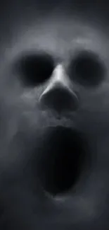 Ghostly face emerging through dark smoke wallpaper.