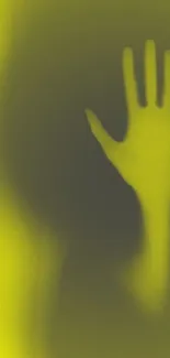 Eerie hand shadow on a yellow background wallpaper.