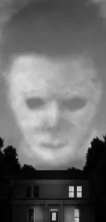 Ominous face in night sky over dark house with trees.