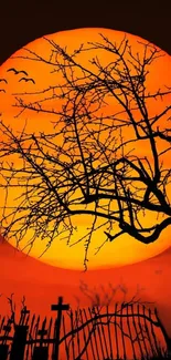 Eerie graveyard with orange sunset backdrop and silhouette branches.