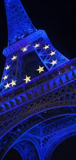 Eiffel Tower illuminated in blue with golden stars at night.