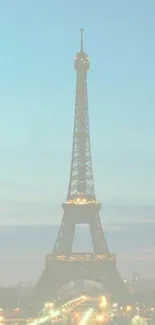 Eiffel Tower illuminated at dusk with a soft evening sky.