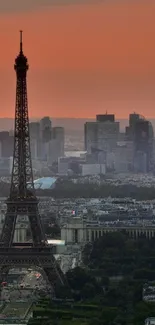 Eiffel Tower and Paris skyline at sunset, with buildings silhouetted against a warm orange sky.