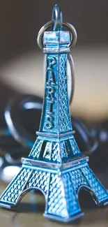 Blue Eiffel Tower keychain wallpaper on mobile screen.