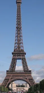 Eiffel Tower against a blue sky with scattered clouds.