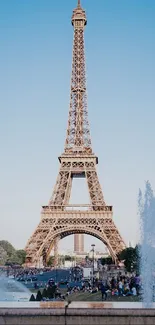 Eiffel Tower under clear blue sky with fountains in foreground.